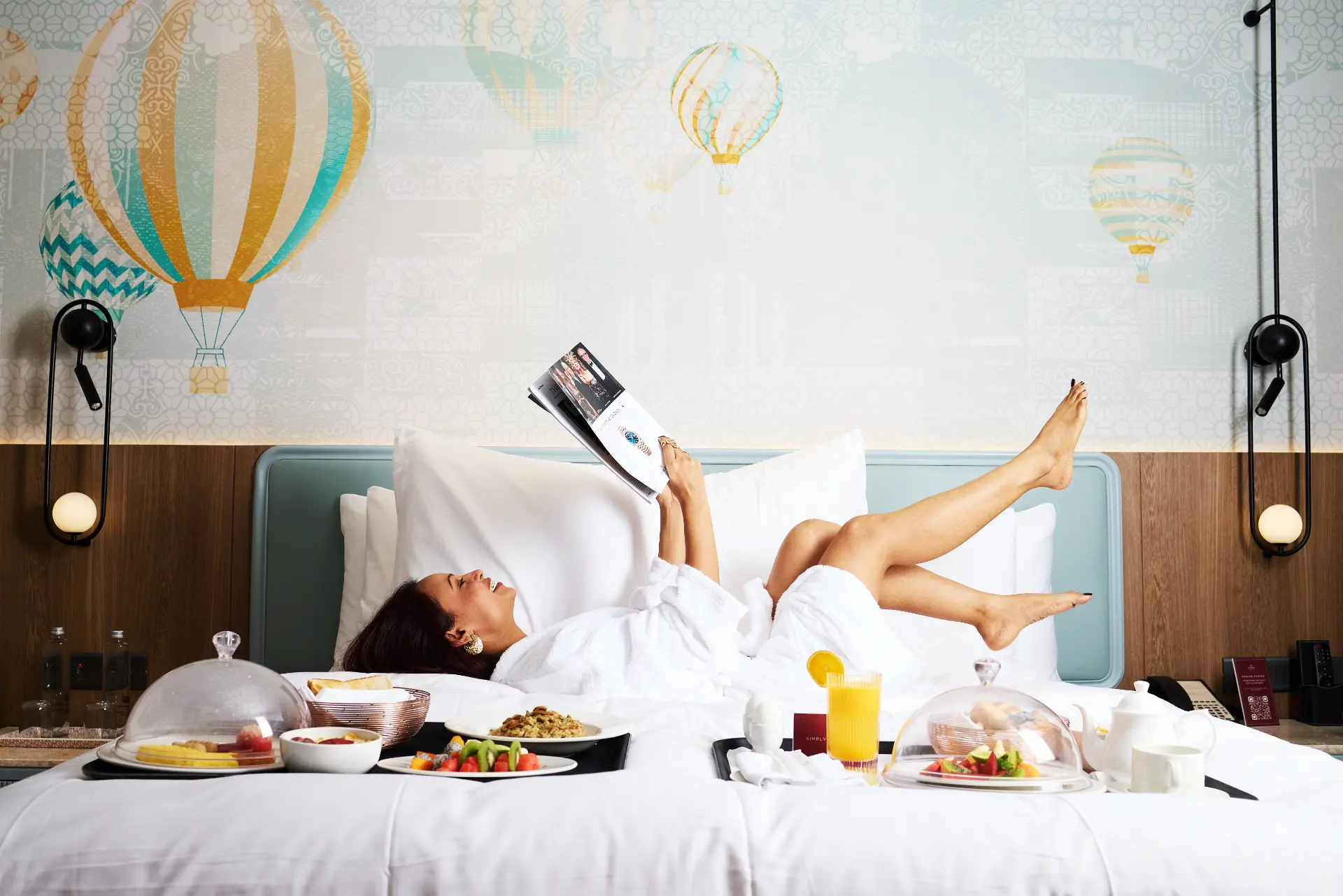 Room service breakfast laid out on an ICONIQA bed
