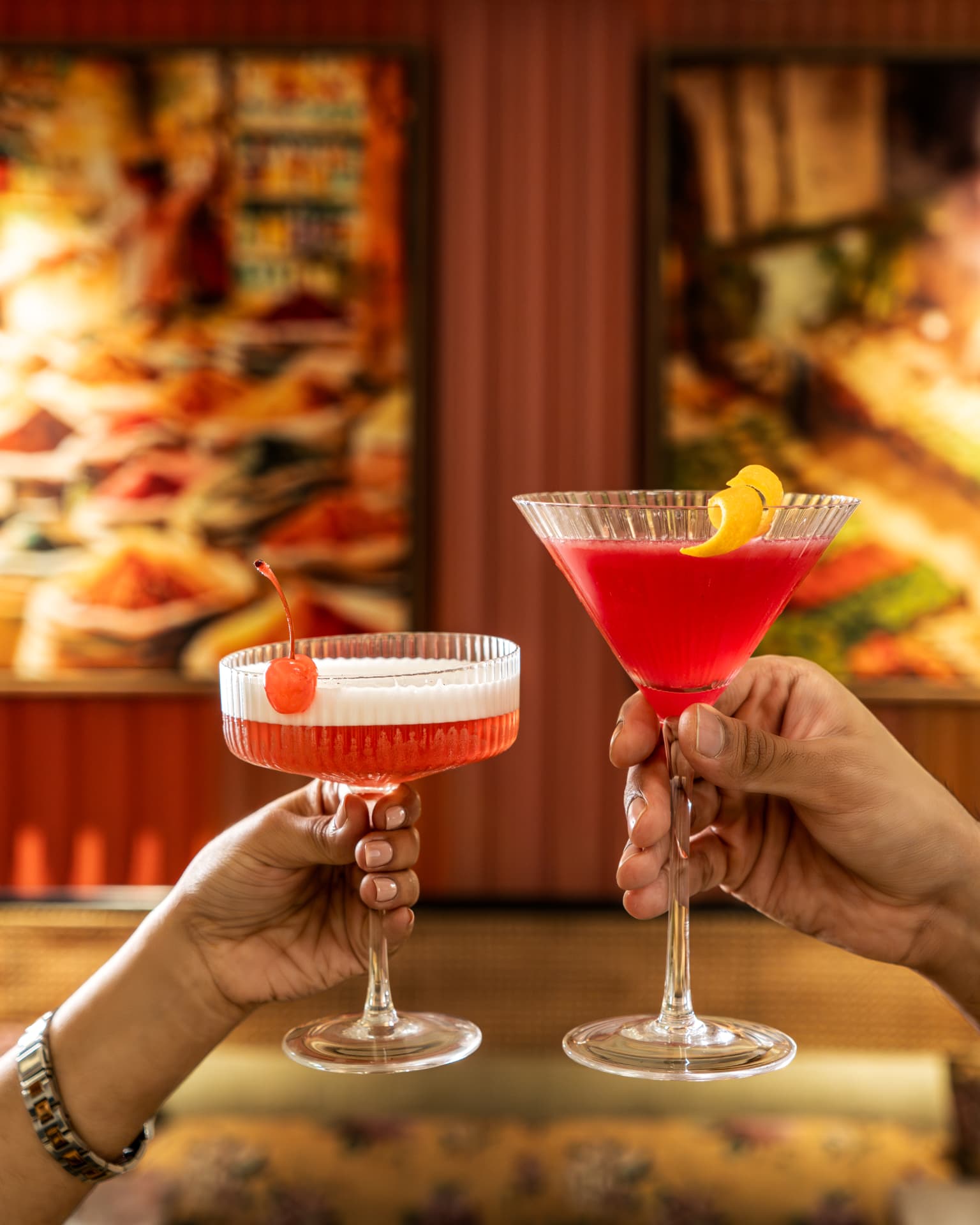 Two guests toasting with cocktails at an ICONIQA bar